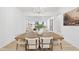 Stylish dining area with a wooden table, white chairs, and a modern chandelier at 3401 Makers Cir, Raleigh, NC 27612