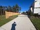 Concrete driveway and wooden fence alongside a grassy area at 3401 Makers Cir, Raleigh, NC 27612