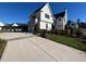 Modern white farmhouse with a two-car garage and fenced yard at 3401 Makers Cir, Raleigh, NC 27612