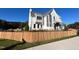Modern farmhouse-style home with a wooden fence and lush green lawn at 3401 Makers Cir, Raleigh, NC 27612