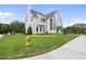 A beautiful white modern farmhouse with a gray roof and lush green lawn at 3401 Makers Cir, Raleigh, NC 27612