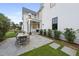 Paved patio with dining table next to a white-sided house with landscaping and path at 3401 Makers Cir, Raleigh, NC 27612