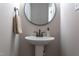 Small bathroom with pedestal sink and round mirror at 204 Cardinal Ct, Oxford, NC 27565