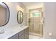 Modern bathroom with double vanity, oval mirror, and glass shower at 206 Cardinal Ct, Oxford, NC 27565
