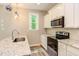 Modern kitchen with white cabinets, granite countertops, and stainless steel appliances at 206 Cardinal Ct, Oxford, NC 27565