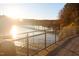 Wooden boardwalk with metal railing overlooking a lake at sunset at 5049 Lundy Dr # 101, Raleigh, NC 27606