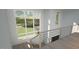 Modern staircase with metal railings overlooking the entryway and backyard at 2332 Windy Woods Dr, Raleigh, NC 27607