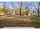 Large backyard with mature trees and a partially fenced area at 329 Roxboro St, Haw River, NC 27258