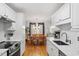 Open concept kitchen with island, white cabinets, and hardwood floors at 127 Lily Xing, Clayton, NC 27527