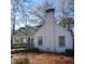 Side view of a white house with a sunroom and multiple windows at 1852 Nc 62 Hwy N, Burlington, NC 27217