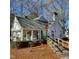 Charming white home with a sunroom, wooden ramp, and landscaping at 1852 Nc 62 Hwy N, Burlington, NC 27217