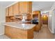 L-shaped kitchen with wood cabinets, built-in oven, and laminate countertops at 317 Quintas Ave, Burlington, NC 27215