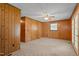 Living room showcasing wood paneled walls, ceiling fan, and carpet at 317 Quintas Ave, Burlington, NC 27215