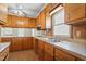 View of kitchen with wood cabinets, double sink, and stovetop at 317 Quintas Ave, Burlington, NC 27215