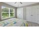 Bedroom with double doors, window with blinds, and carpet flooring at 3455 Piedmont Dr, Raleigh, NC 27604