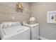 Bright laundry room with washer, dryer, and shelving at 3455 Piedmont Dr, Raleigh, NC 27604