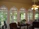 Sunroom with multiple windows offering scenic views and wicker furniture at 236 Olde Ferry Ln, Dunn, NC 28334