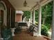 Inviting front porch with rocking chairs, a swing, and brick flooring at 236 Olde Ferry Ln, Dunn, NC 28334