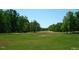 Open land with lush green grass and mature trees at 236 Olde Ferry Ln, Dunn, NC 28334