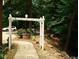 Landscaped walkway leading through a garden with a white arbor at 236 Olde Ferry Ln, Dunn, NC 28334