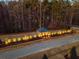 Aerial view of community entrance with gatehouse and lighting at 114 Mountaintop Cir, Pittsboro, NC 27312