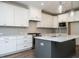 Modern kitchen with white cabinets, gray island, and stylish light fixtures at 1717 Grassy Falls Ln, Wendell, NC 27591