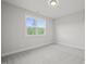 Well-lit bedroom featuring grey carpet and a window at 85 Harvest View Way, Franklinton, NC 27525