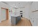 Modern kitchen with white cabinets, gray island, and stainless steel appliances at 530 Husketh Rd, Youngsville, NC 27596
