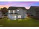 Two-story house exterior view at dusk with a covered patio and grassy lawn at 545 Husketh Rd, Youngsville, NC 27596