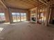 Open living room under construction with sliding glass doors and fireplace at 4905 Hidden Pasture Way, Zebulon, NC 27597