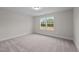 Simple bedroom with gray carpeting and a window showing a view at 818 Pryor St # 55, Mebane, NC 27302
