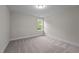 Simple bedroom with gray carpeting and a window with natural light at 818 Pryor St # 55, Mebane, NC 27302