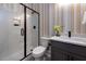 Modern bathroom with a glass shower, gray vanity, and stylish wallpaper at 4213 Burlington Mills Rd, Wake Forest, NC 27587