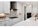 Modern kitchen with white cabinets, chevron backsplash, and high-end appliances at 4213 Burlington Mills Rd, Wake Forest, NC 27587
