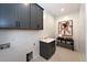 Bright laundry room featuring stylish dark gray cabinets and a clean design at 4213 Burlington Mills Rd, Wake Forest, NC 27587