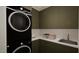 Modern laundry room with stacked washer/dryer and ample cabinet space at 13625 Old Creedmoor Rd, Wake Forest, NC 27587
