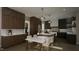 Modern kitchen with dark wood cabinets, white counters, and island at 13625 Old Creedmoor Rd, Wake Forest, NC 27587