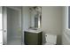 Contemporary bathroom with green vanity and gold fixtures at 13625 Old Creedmoor Rd, Wake Forest, NC 27587