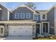 Exterior view of a two-story townhome with gray siding and a stone facade at 2321 Sugar Cone Way, Fuquay Varina, NC 27526