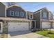 Two story townhome with gray siding, stone accents, and a two car garage at 2321 Sugar Cone Way, Fuquay Varina, NC 27526