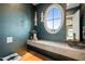 Elegant powder room with marble vanity and oval window at 8916 Grand Highland Way, Wake Forest, NC 27587