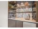 Modern wet bar with mirrored backsplash and beverage fridge at 8916 Grand Highland Way, Wake Forest, NC 27587