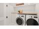 Well-appointed laundry room with stackable washer and dryer, and wooden countertop at 8916 Grand Highland Way, Wake Forest, NC 27587
