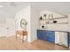Stylish bar area with blue cabinetry, floating shelves, and a mini-fridge at 8916 Grand Highland Way, Wake Forest, NC 27587