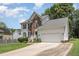 Two story brick and white sided home with attached garage and driveway at 2205 Moon Water Way, Garner, NC 27529