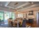 Open dining area with farmhouse table, chandelier, and access to outdoor patio at 410 Firefly Overlook, Pittsboro, NC 27312