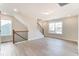 Bright bonus room with hardwood floors, two windows and a staircase at 2023 Seneca Dr # 32, Raleigh, NC 27604