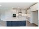 Modern kitchen boasts white cabinets, a large island with quartz countertops, and stainless steel appliances at 2023 Seneca Dr # 32, Raleigh, NC 27604