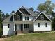 Two-story home with white and dark gray siding, brick accents, and large windows at 190 Whistlers Cv, Louisburg, NC 27549