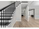 Entryway with black metal staircase and light hardwood floors at 190 Whistlers Cv, Louisburg, NC 27549